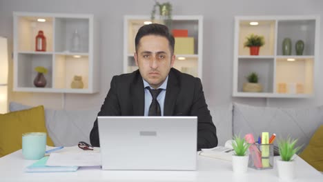 Home-office-worker-man-looking-at-camera-depressed.